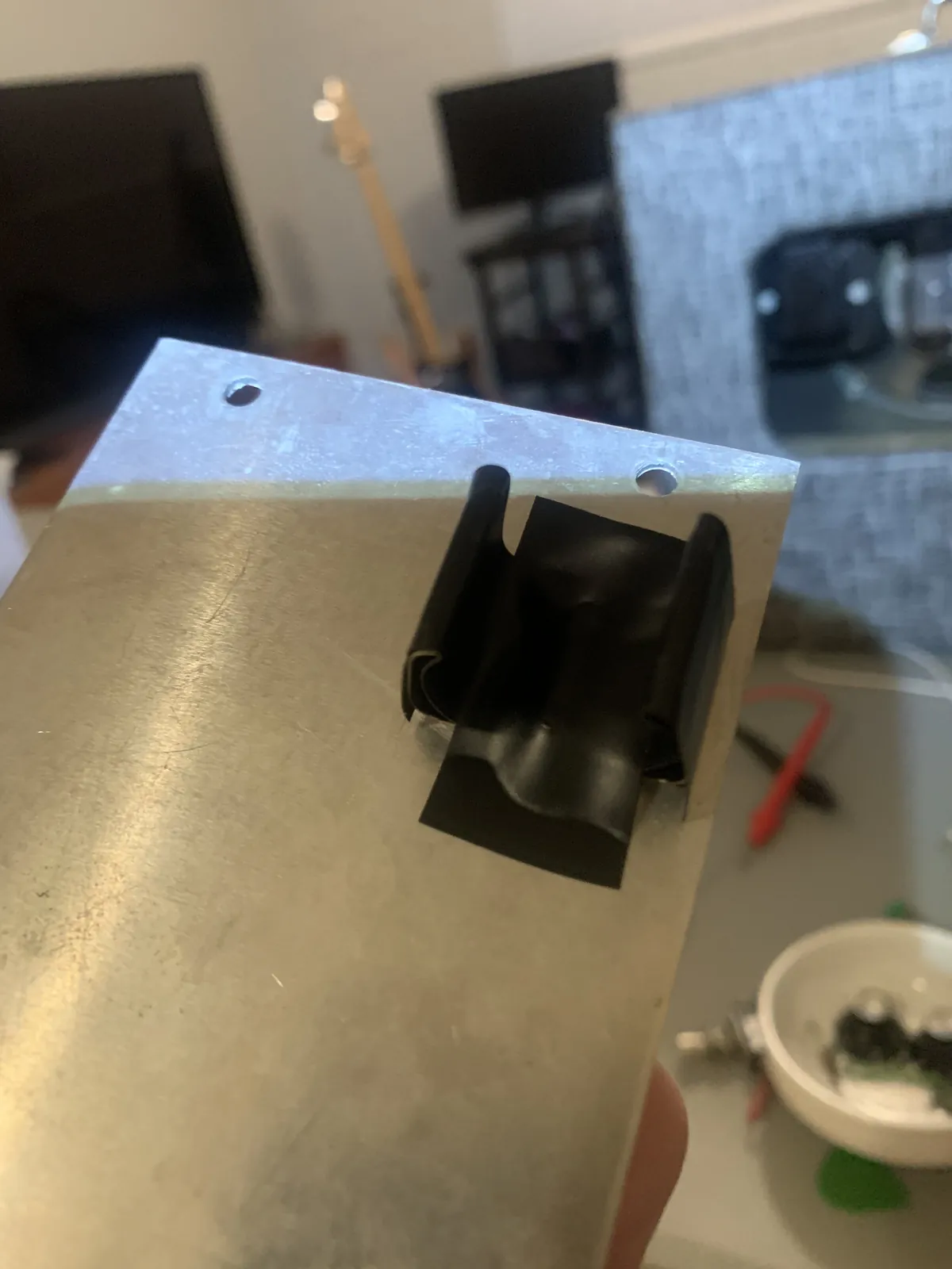 Battery clip on the inside of the back panel covered in black electrical tape
