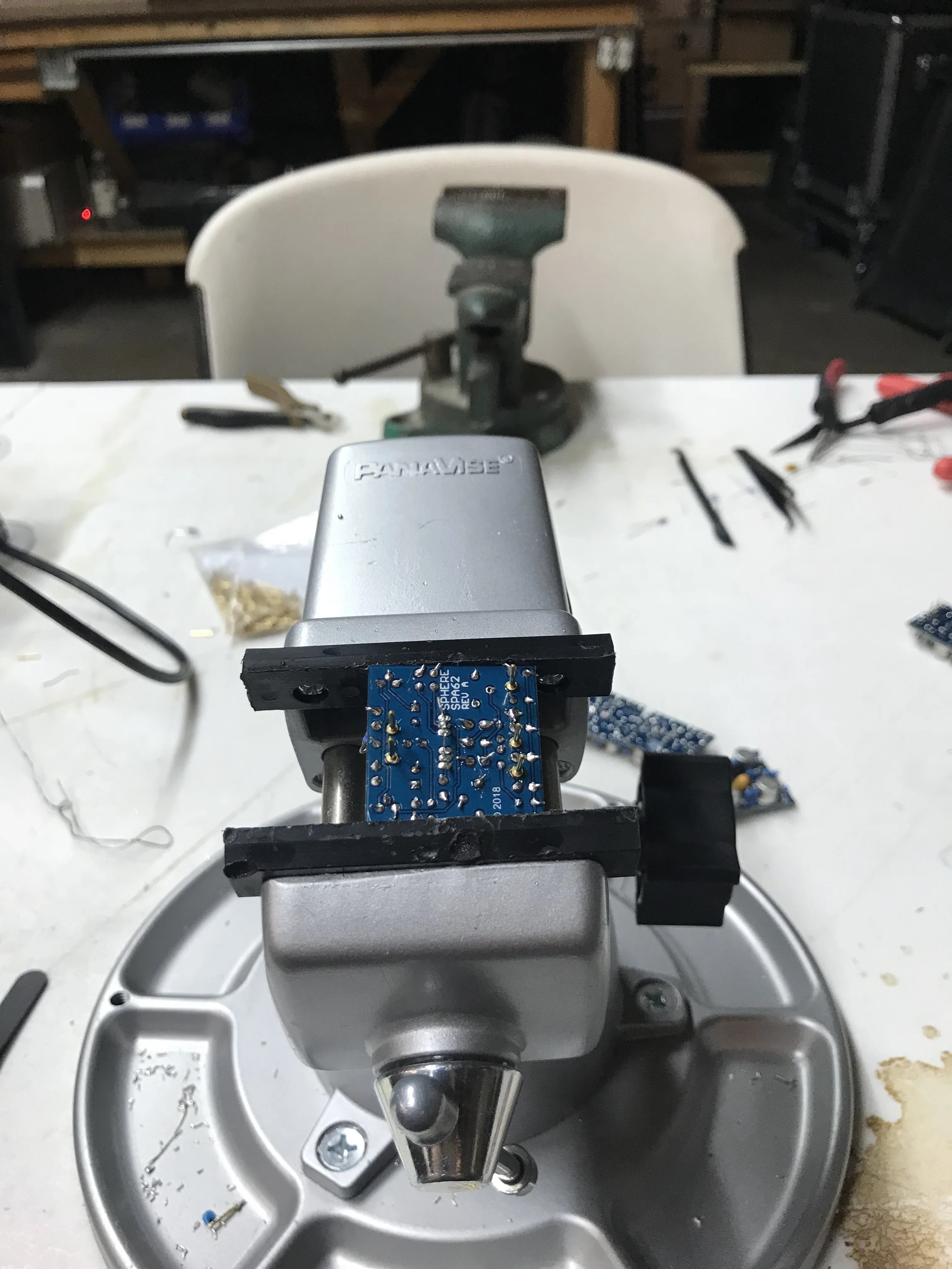SPA62 op amp held in a vise during soldering after population